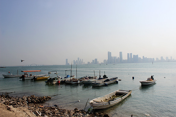 Fishing boats in historical Al-Muharraq overlooking modern Manama.