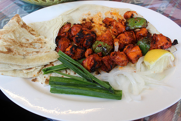 Chicken tikka kebabs, Bahraini bread, green onions, and a sliver of lime.