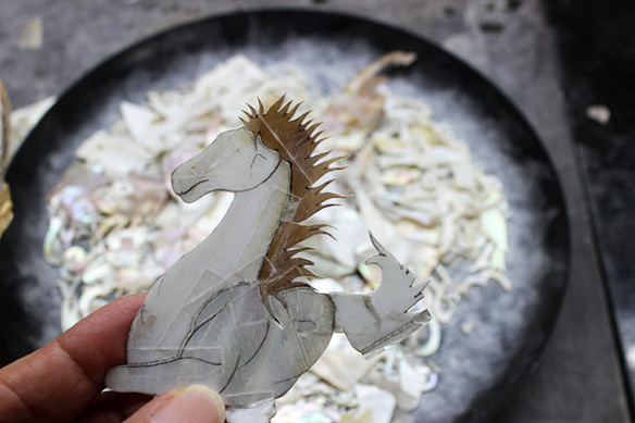 A patch-worked mother-of-pearl horse that will become part of an exquisite lacquered artifact at Lang Viet/ Handicapped Handicrafts' workshop-cum-showroom.