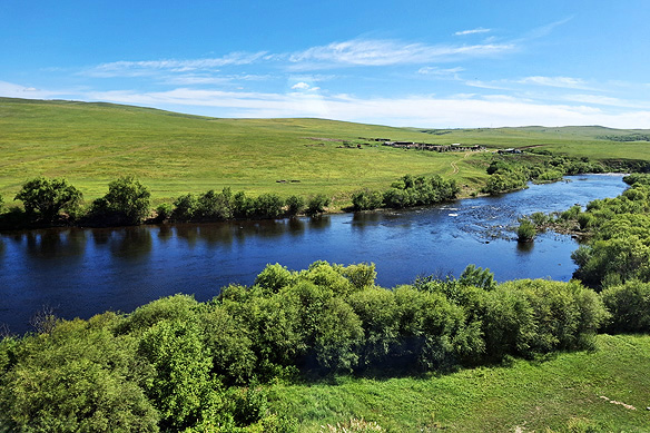 A tiny village nestled in velvety meadows sliced by wide placid rivers.