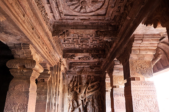 Sculptural relief in Cave 2 narrates the story of Vishnu's 5th avatar, Vamana, in which he transforms into the towering Trivikrama to defeat the evil King Mahabali. The ceiling is decorated with a Matsya Chakra [Fish Wheel] and Swastika patterns.